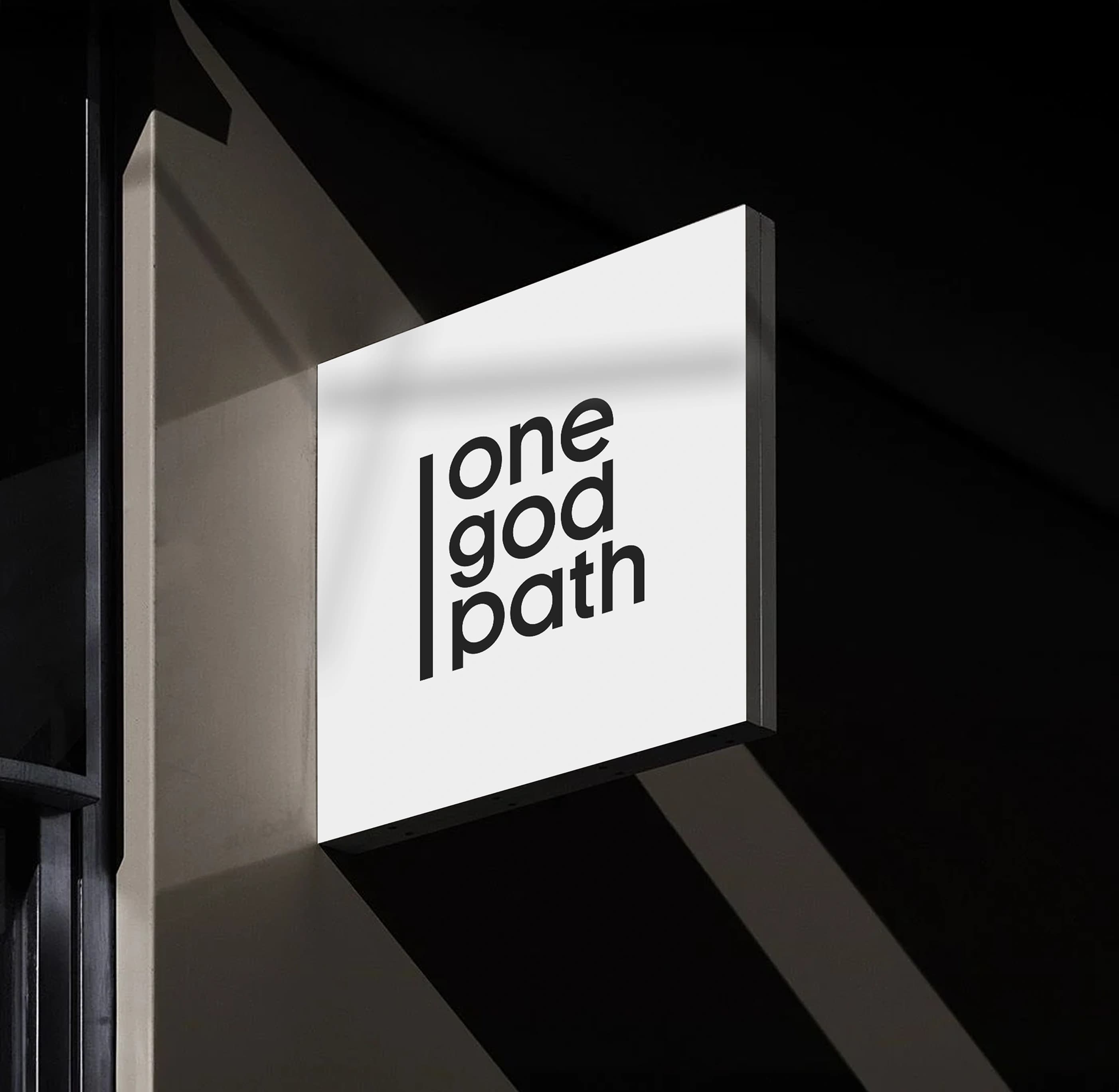 An illuminated projecting blade sign carrying the one god path logo juts from a dark building corner at night.