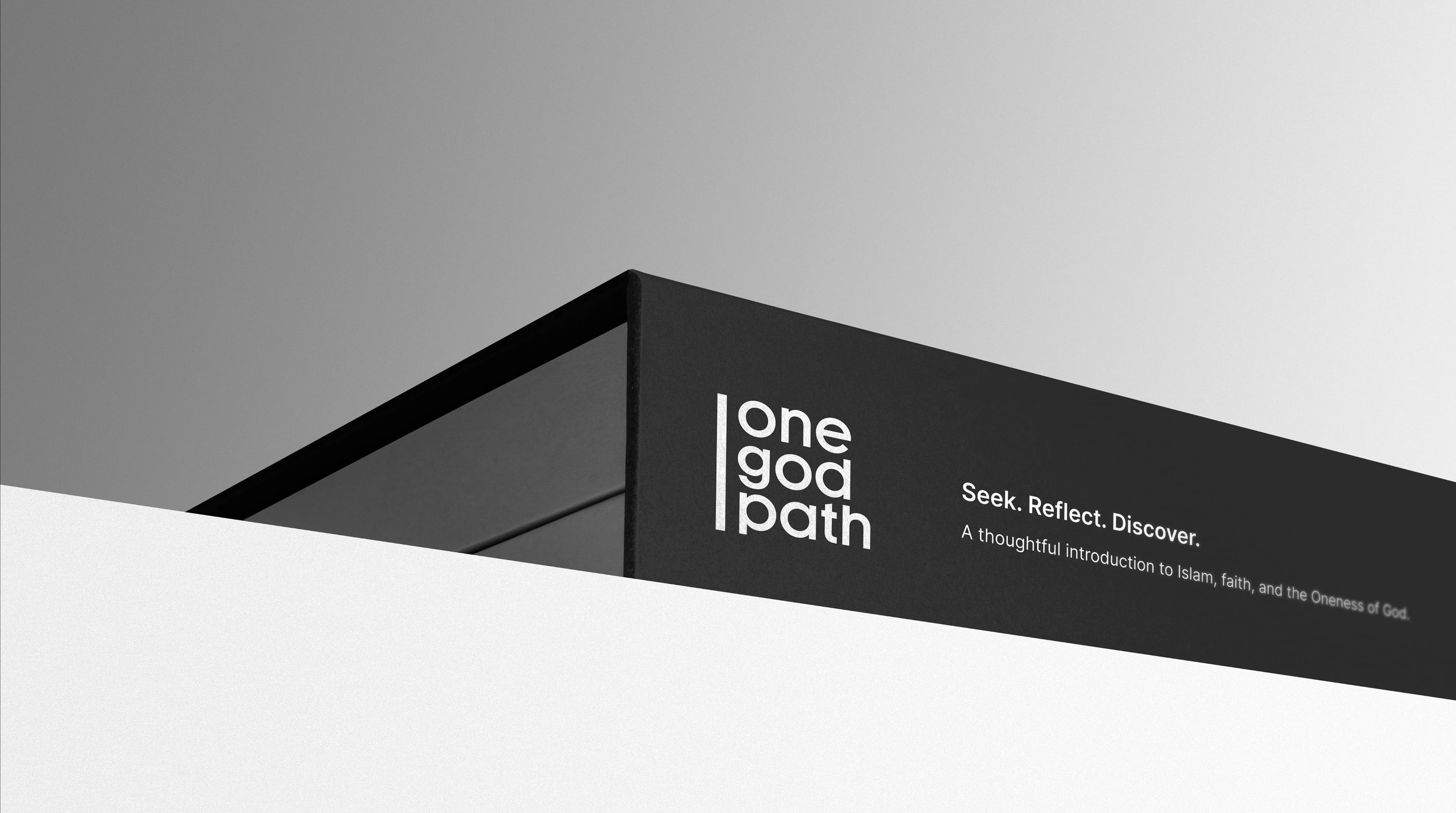 A dark matte signage fascia wraps a building corner against a pale sky, carrying the one god path logo and the Seek. Reflect. Discover. tagline.