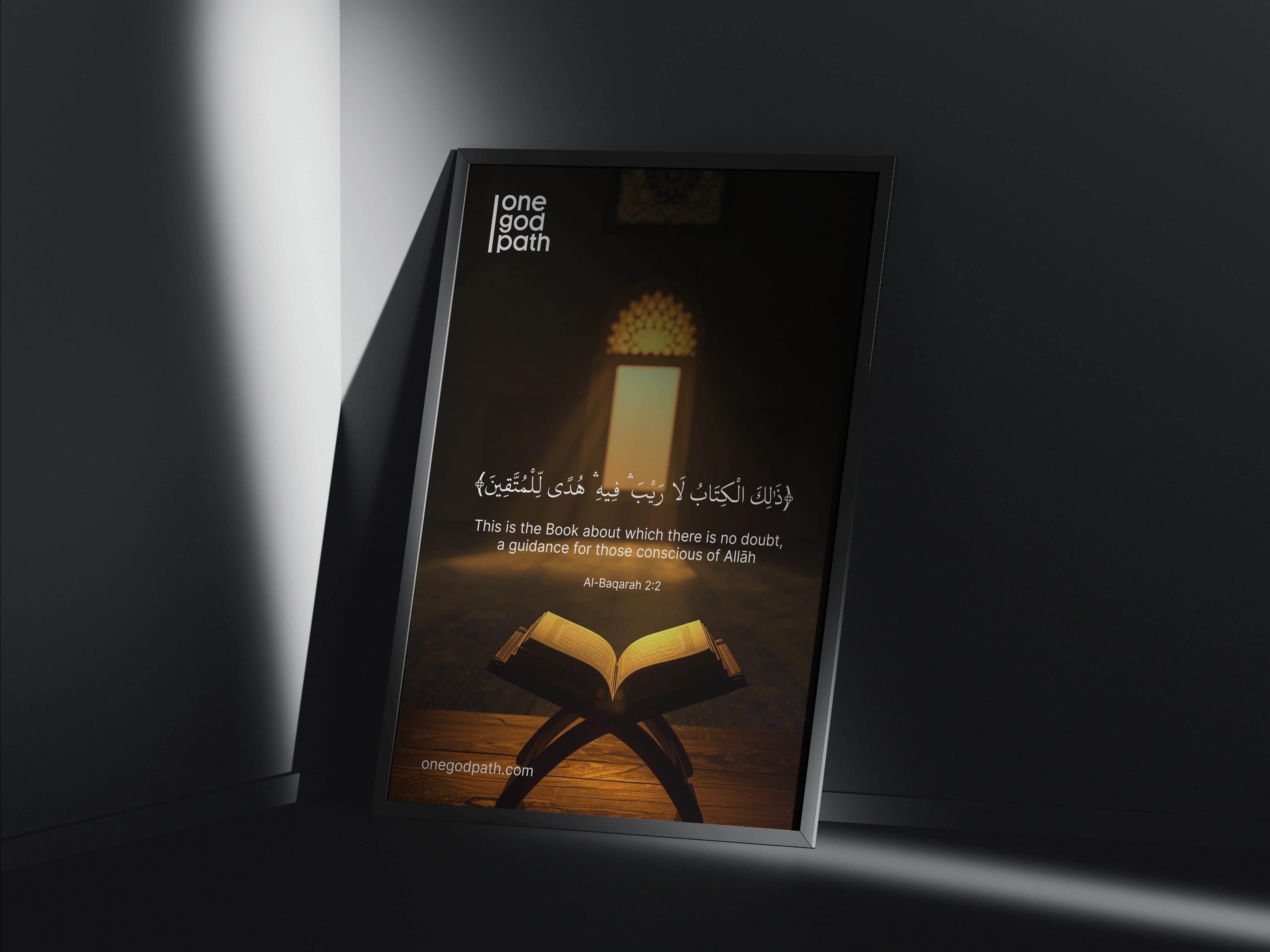 A framed poster leans in a dark corner under a shaft of light, showing the one god path logo with Al-Baqarah 2:2 in Arabic and English.