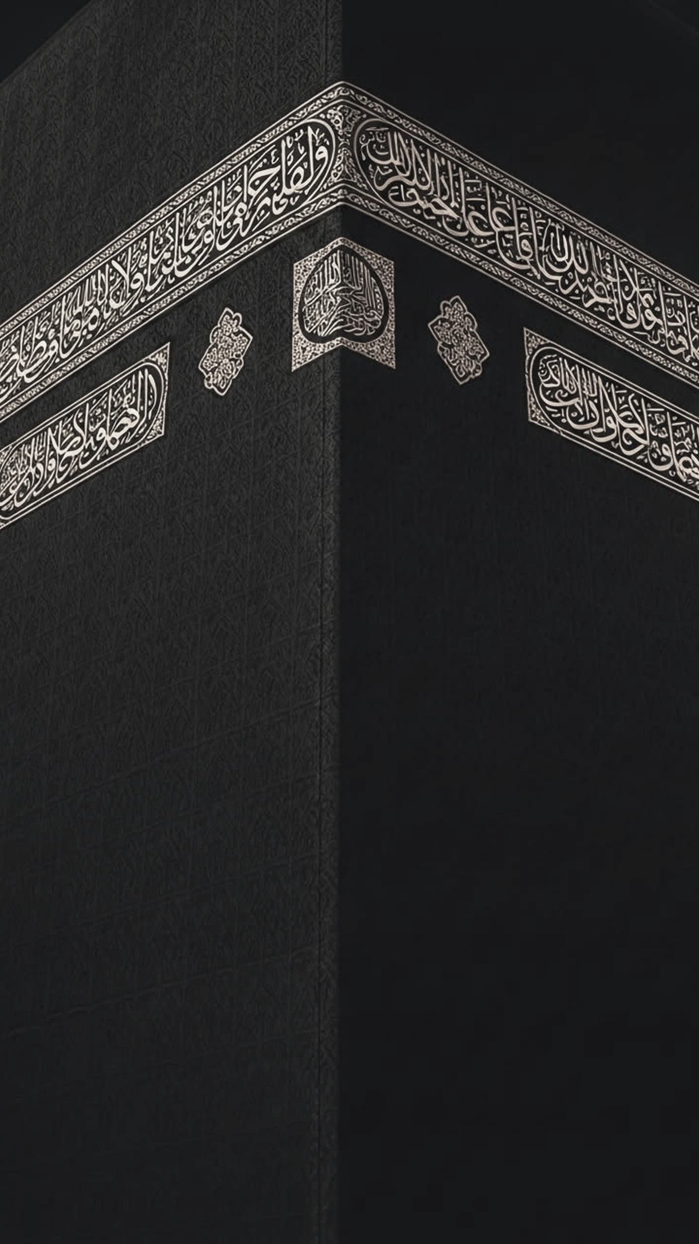 The corner of the Kaaba draped in the black kiswah, the silver-thread hizam calligraphy belt and its medallion wrapping both faces.