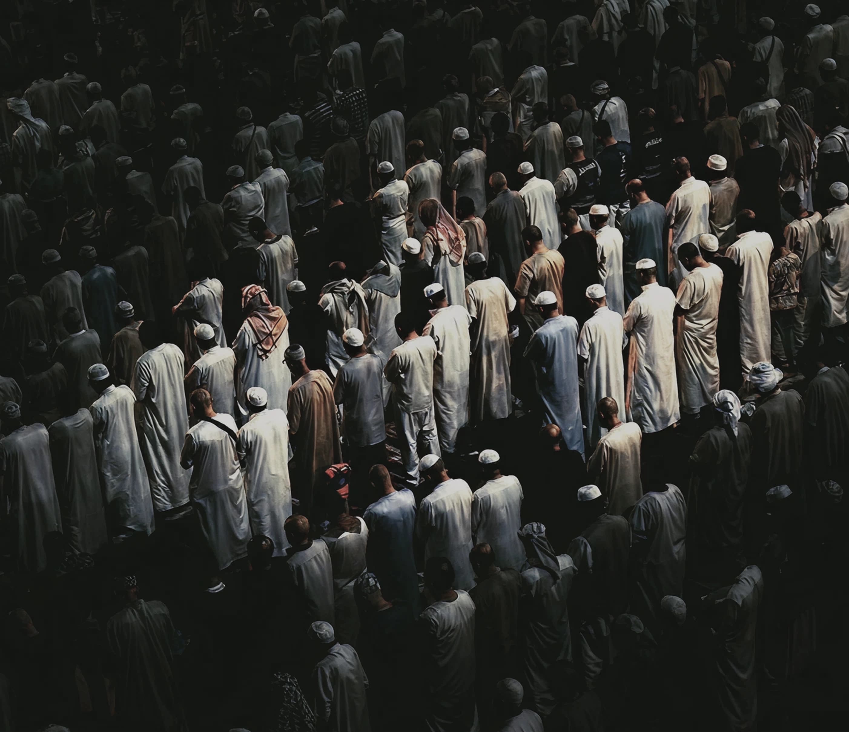 Dense rows of worshippers stand shoulder to shoulder in prayer, seen from above.