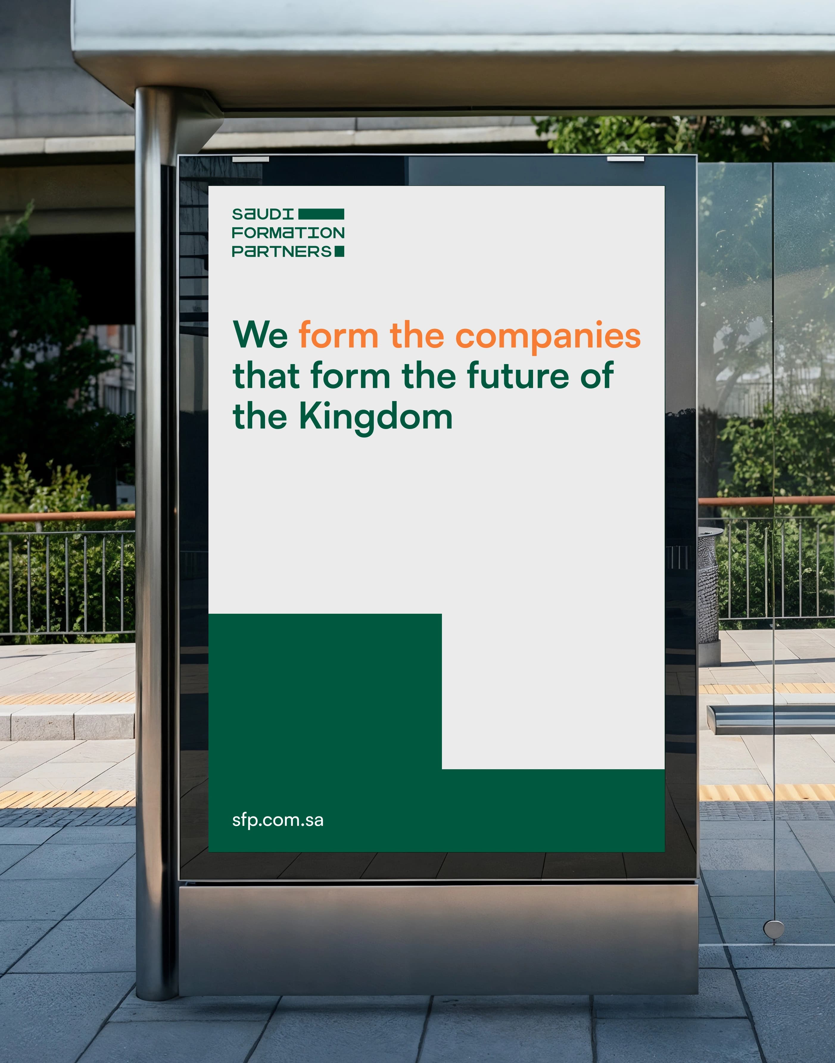 A street bus shelter carrying an off-white poster, the Saudi Formation Partners wordmark at its top left above a headline set two-tone in orange and dark green, with a stepped green block at the foot holding the website address.