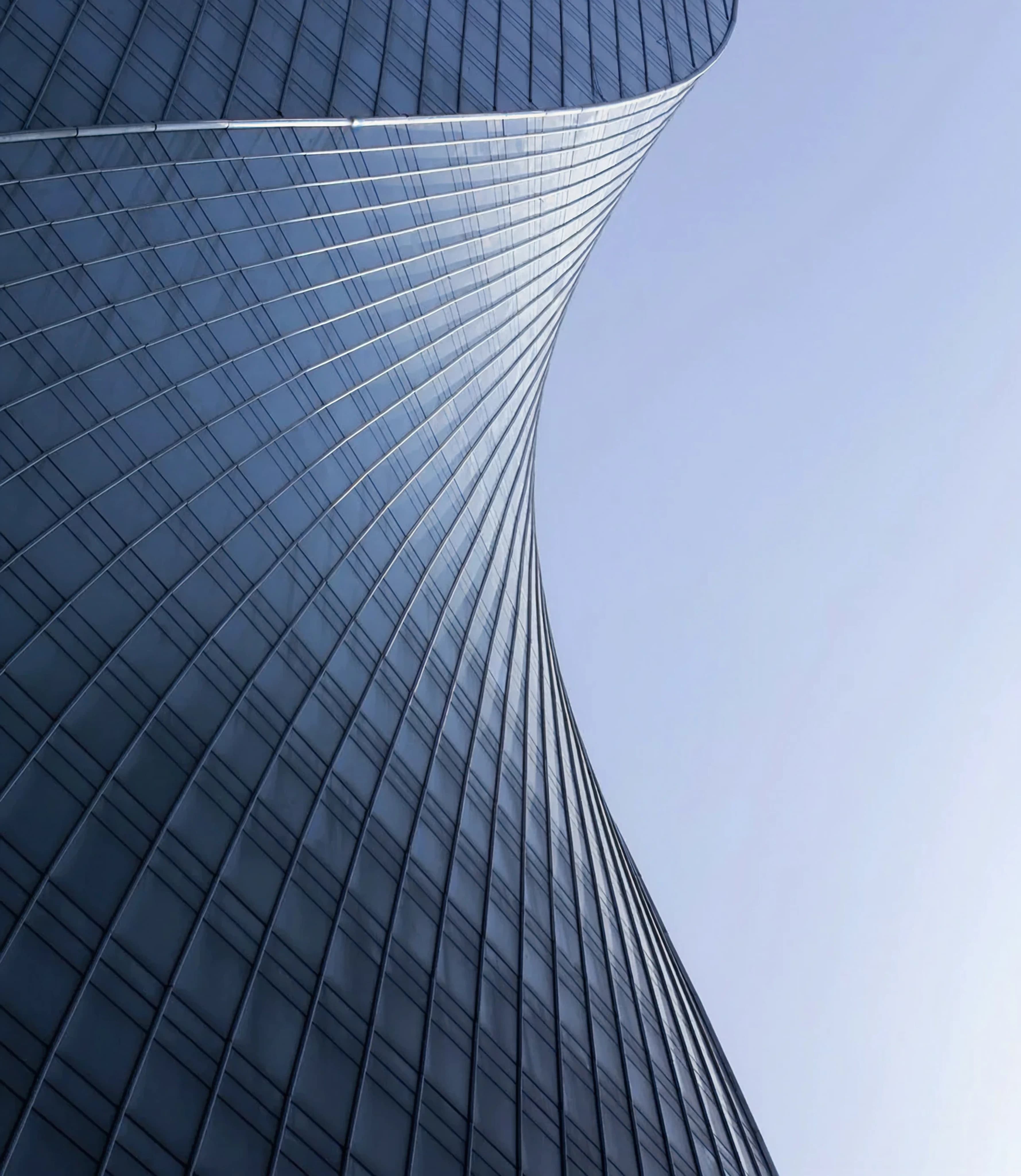 The facade of a curved glass tower photographed from below, filling the frame as the creative behind an Instagram story headline.
