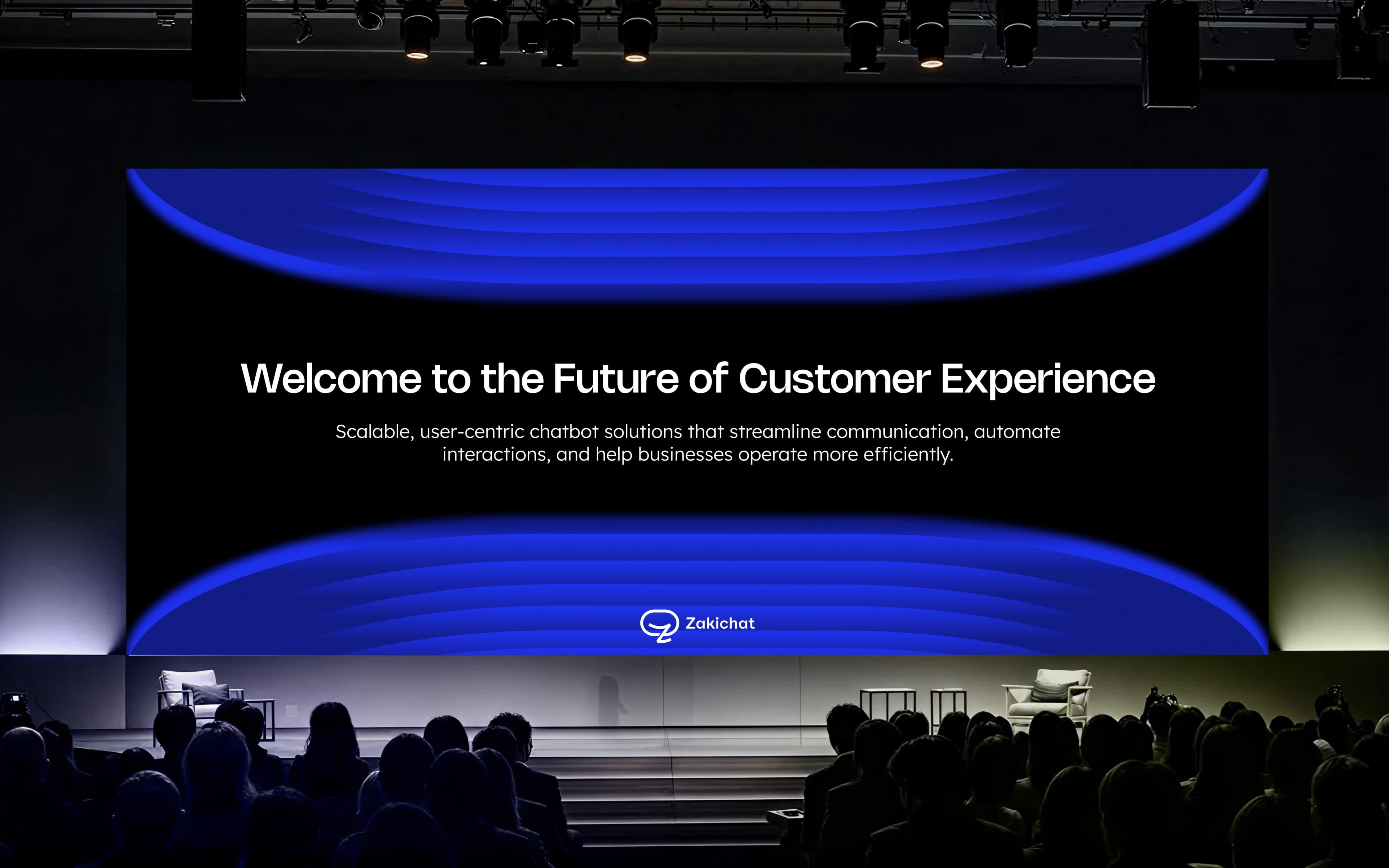 Zakichat — conference stage screen A darkened auditorium seen over silhouetted audience heads toward a wide LED stage screen showing Welcome to the Future of Customer Experience with a two-line subhead and the Zakichat lockup beneath.